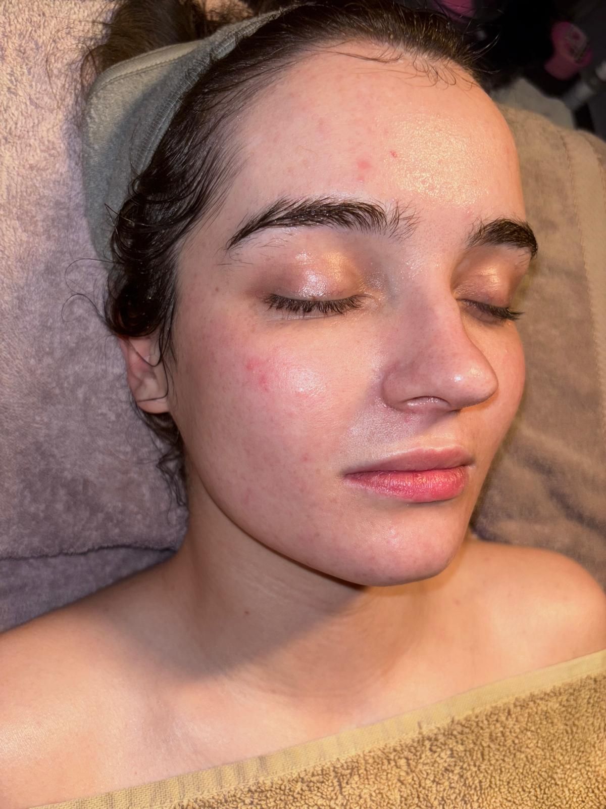 Relaxed client with glowing, hydrated skin during a facial